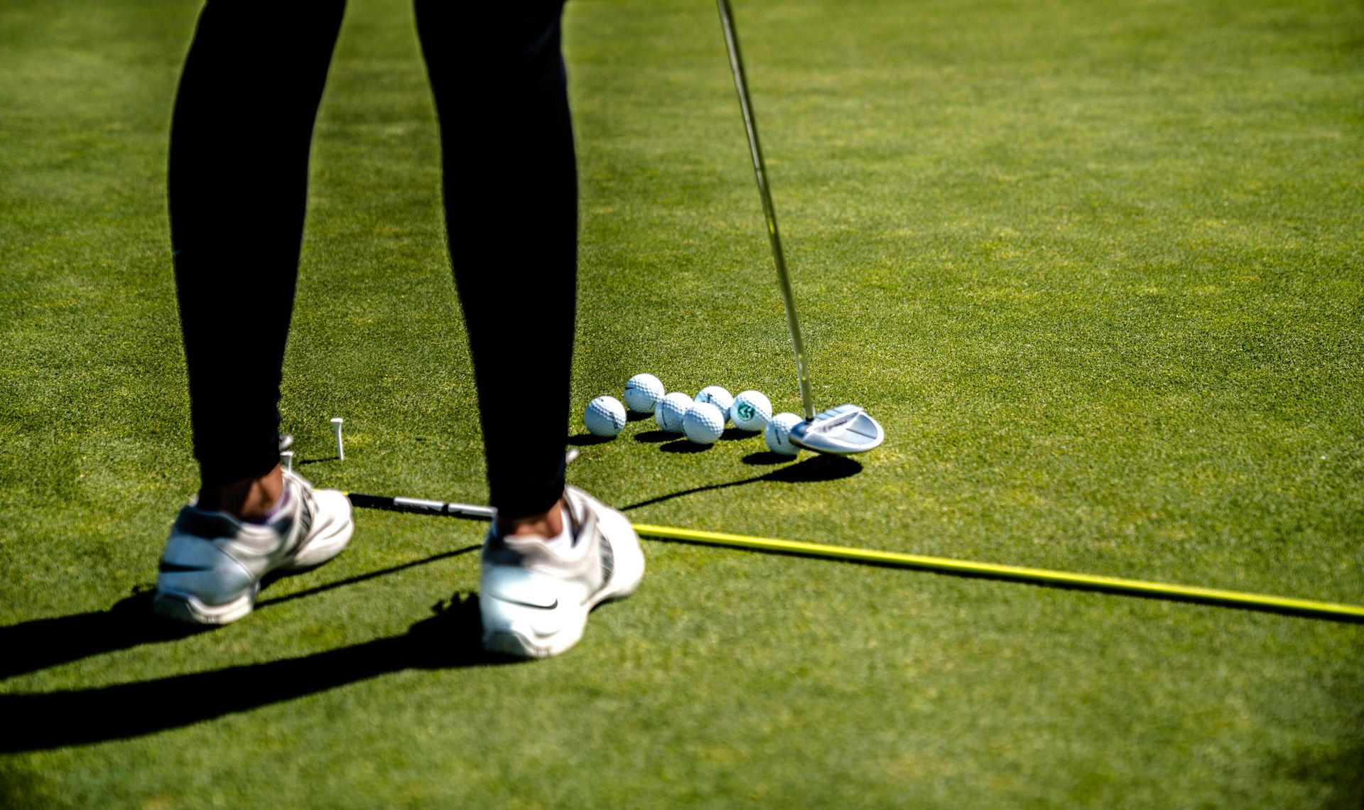 Golfer practicing with clubs on a practice area